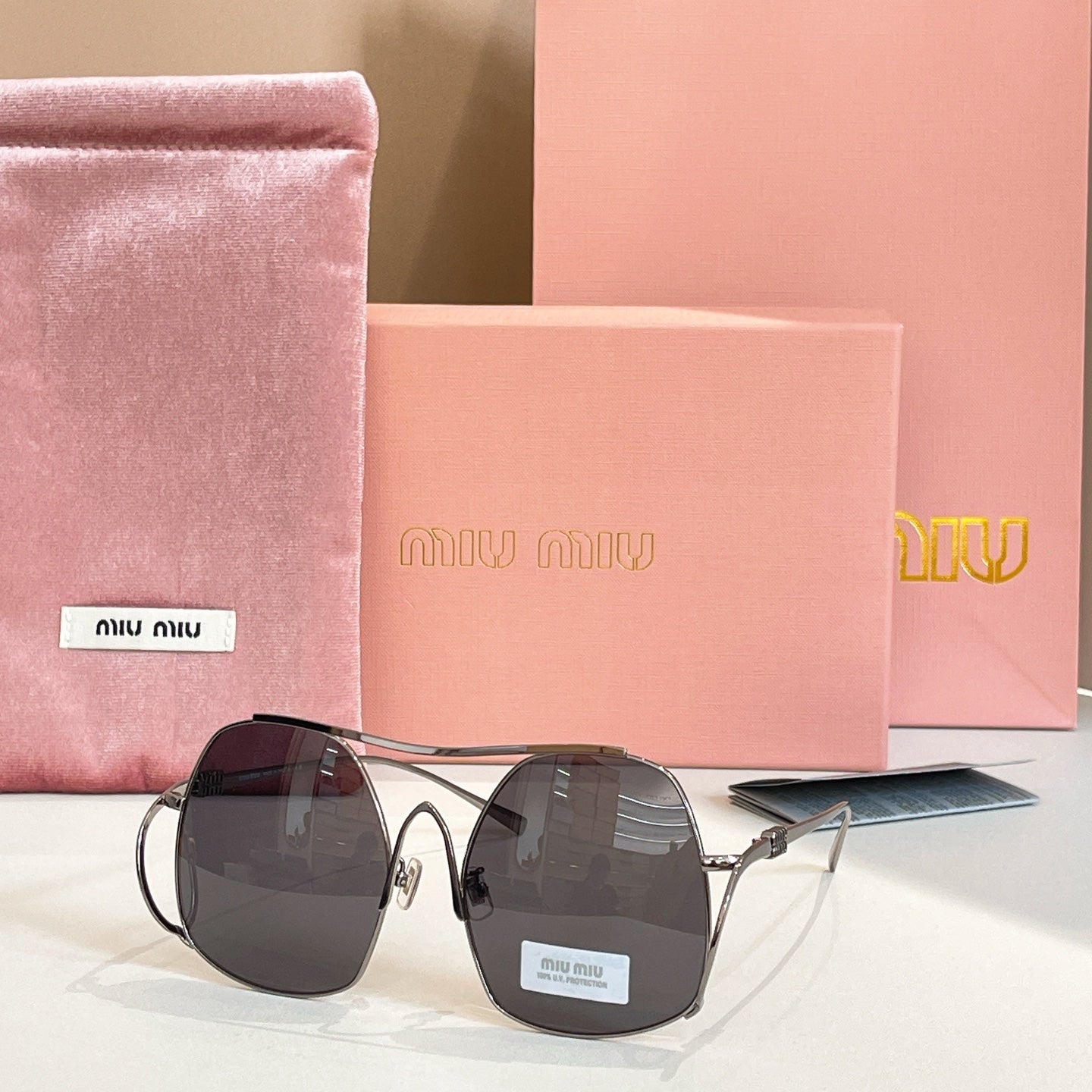 MiuMiu gold-tone sunglasses with dark black tinted round lenses