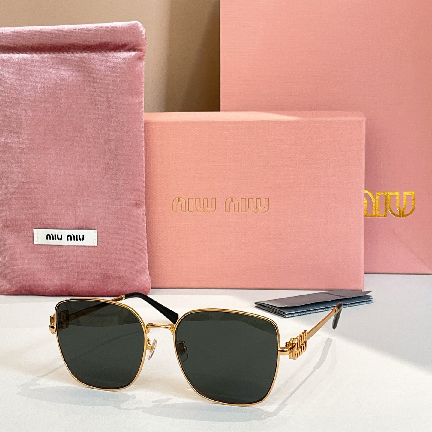 Square sunglasses with gold frame and dark green gradient lenses.