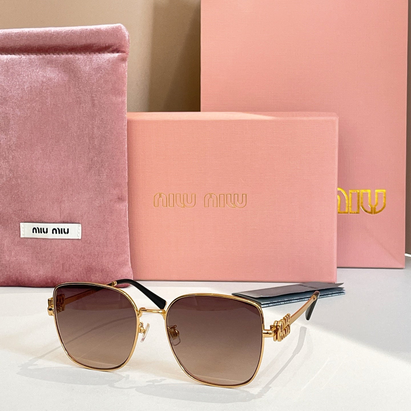 Square sunglasses with gold frame and dark brown gradient lenses.