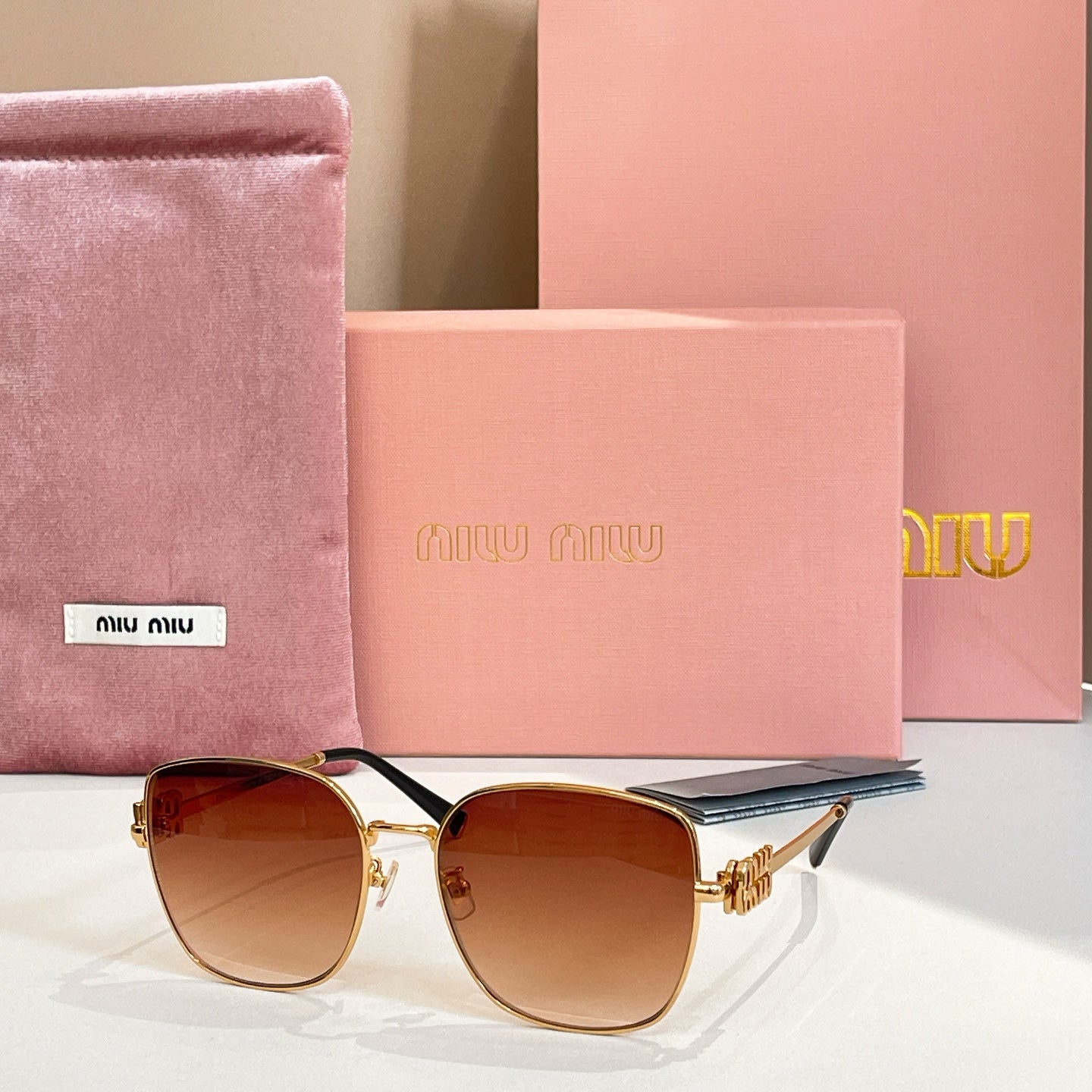 Square sunglasses with gold frame and dark brown gradient lenses, side view.