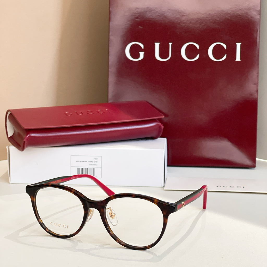 Gucci eyeglasses with dark frames and red temple tips, round clear lenses