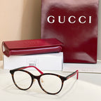 Gucci eyeglasses with dark frames and red temple tips, round clear lenses