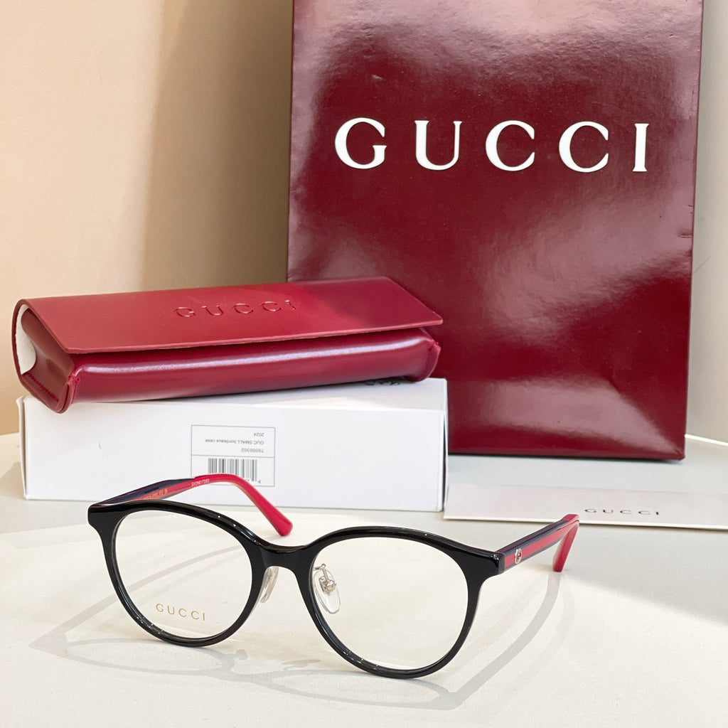 Gucci eyeglasses with black frames and red temple tips, clear round lenses