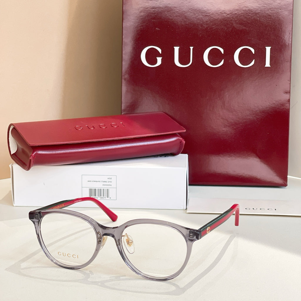 Gucci eyeglasses with gray frames and red temple tips, clear round lenses