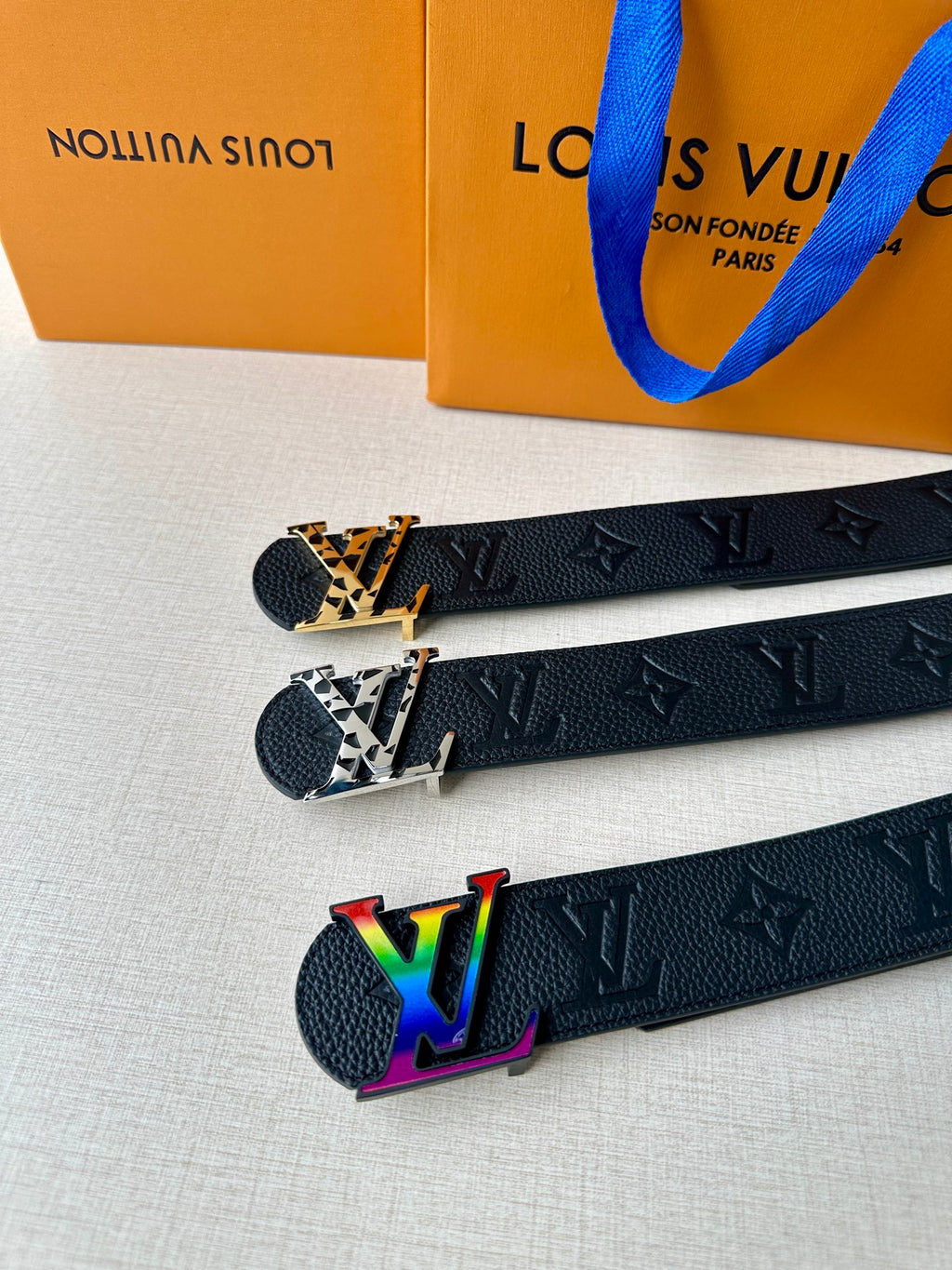 Dark leather belts with LV monogram texture and multicolor LV buckle variants