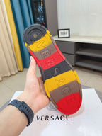 Versace luxury sneakers outsole view: multicolor rubber tread with logo print.