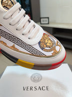 Versace luxury sneakers toe view: white laces, gold ornament and Greek border trim.