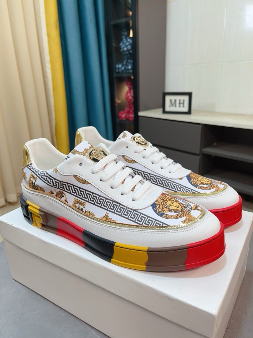 Versace luxury sneakers pair, white uppers with Greek border and gold crest accents.