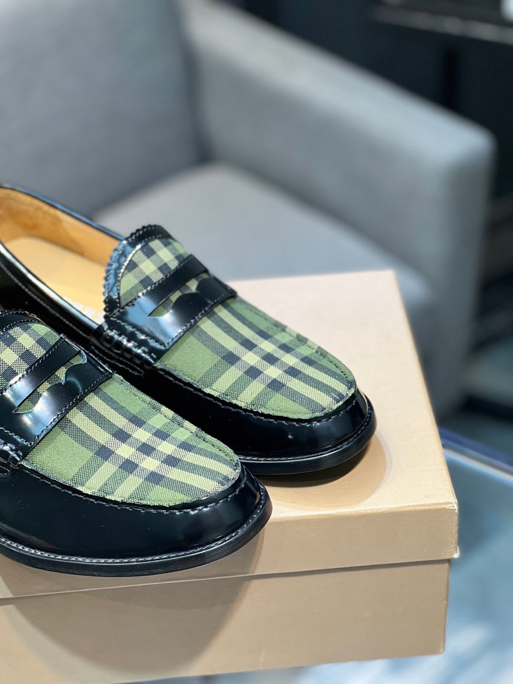 Burberry plaid loafer close-up, black leather strap over green tartan fabric