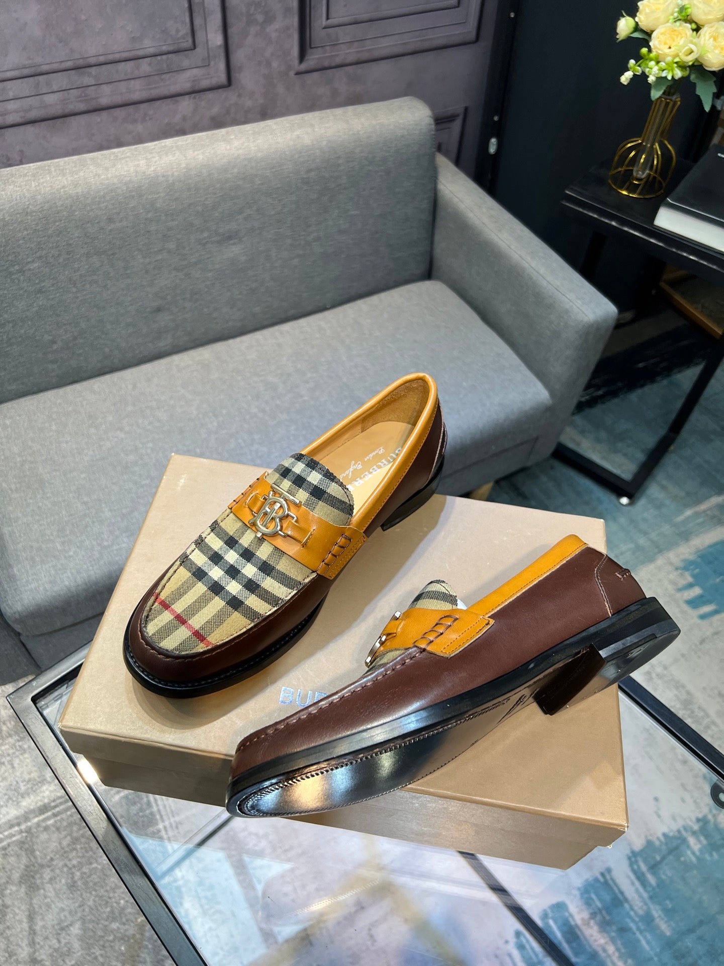 Brown leather loafer with tan plaid upper and gold buckle ornament, side view