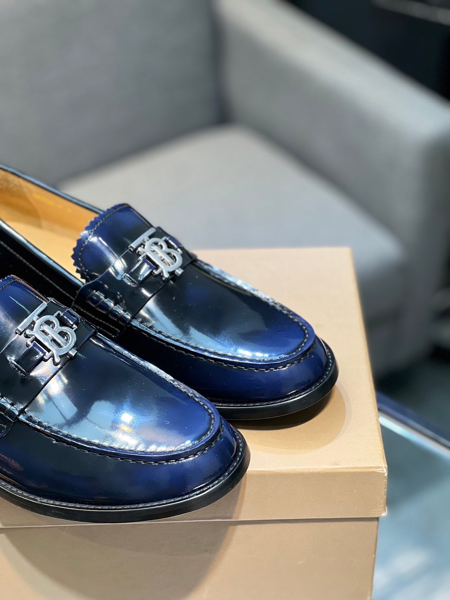 Burberry navy patent leather loafers with TB buckle detail, close side angle
