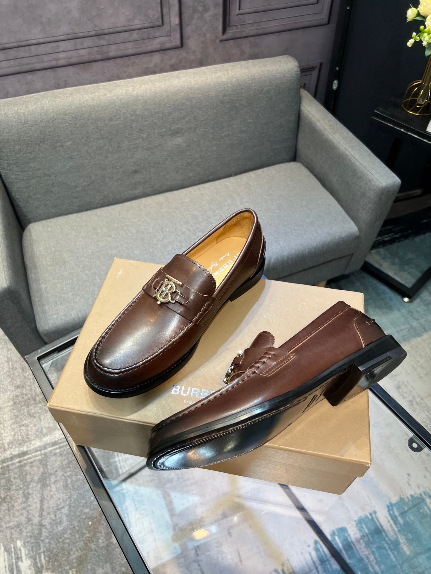 Brown leather loafer shoes with metal TB buckle detail and black sole