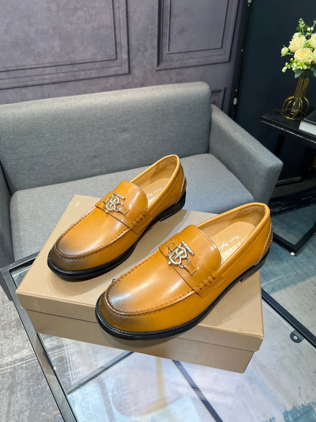 Burberry tan leather slip-on loafers with TB metal emblem and black sole