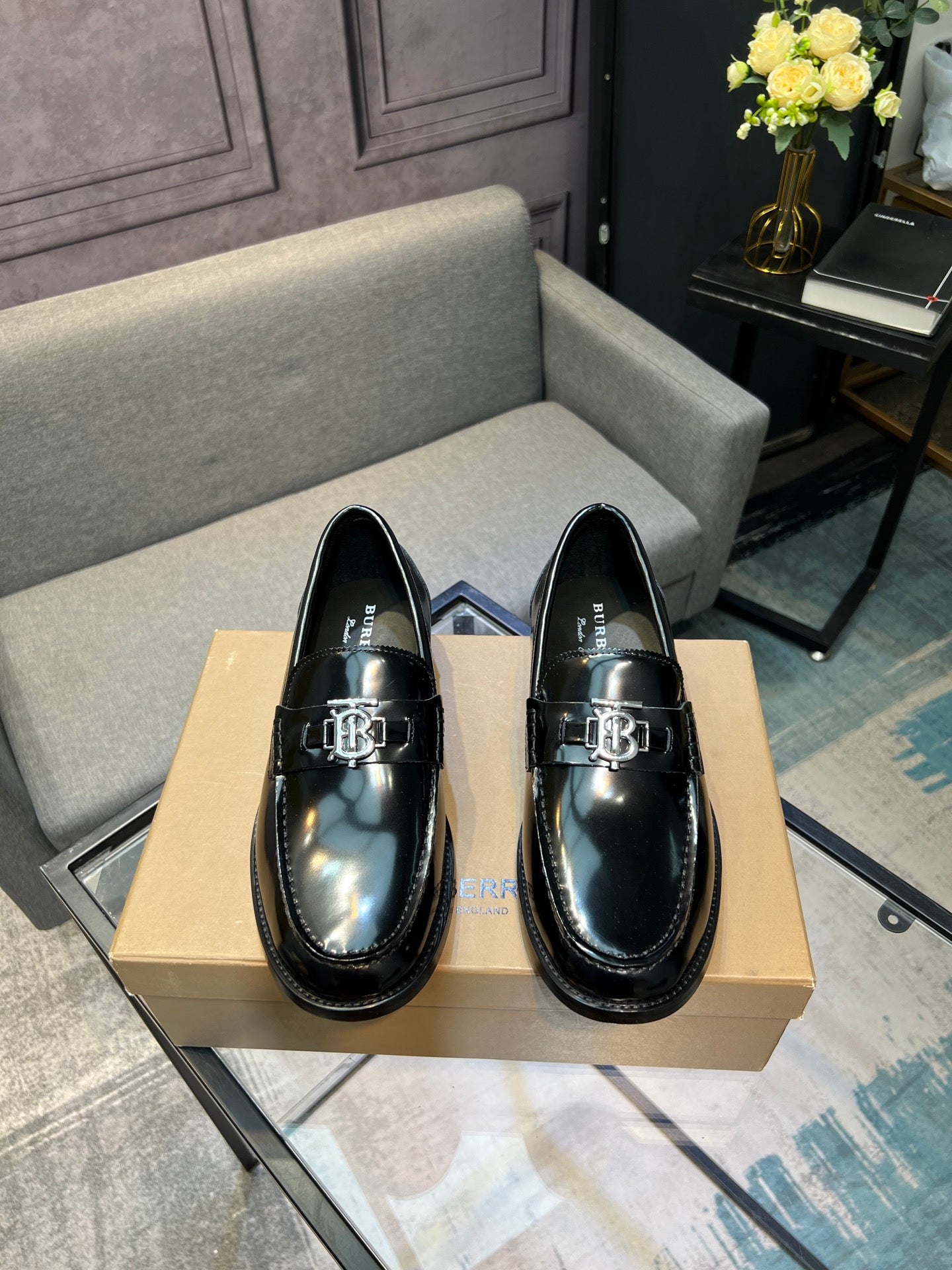 Black leather loafer shoes with metal buckle detail and stitched moc toe