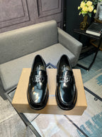 Black leather loafers with silver metal bit detail and stitched apron