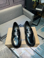 Black leather loafers with silver buckle/bit detail, slip-on style