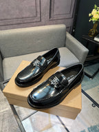 Black leather loafer shoes, side view with metal buckle and glossy finish