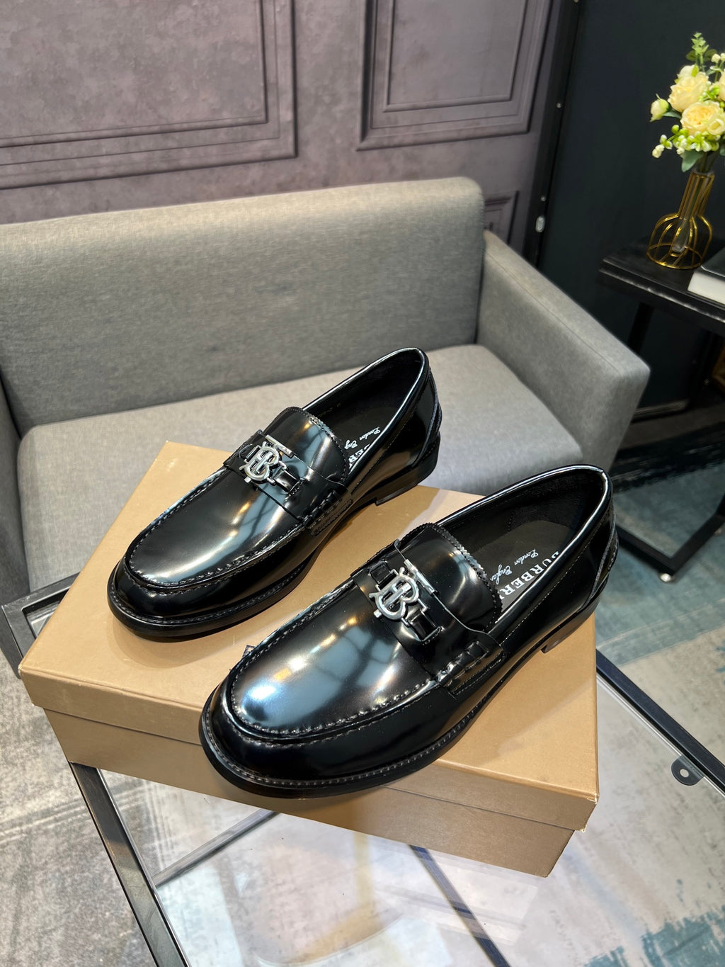 Black leather loafers with silver metal bit detail, glossy upper
