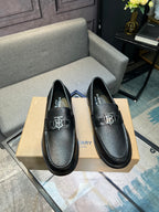 Burberry black leather loafers with metal TB logo on strap, front view pair