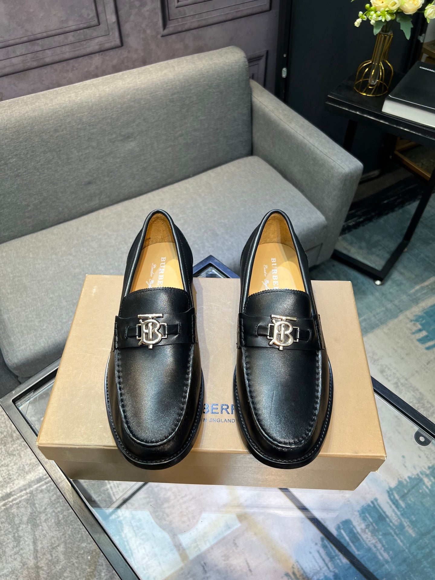 Burberry dark leather loafer with metal buckle, front view on box