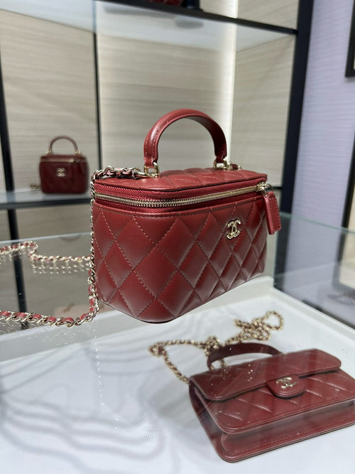 Quilted dark red mini bag with top handle, chain strap, and gold-tone clasp.