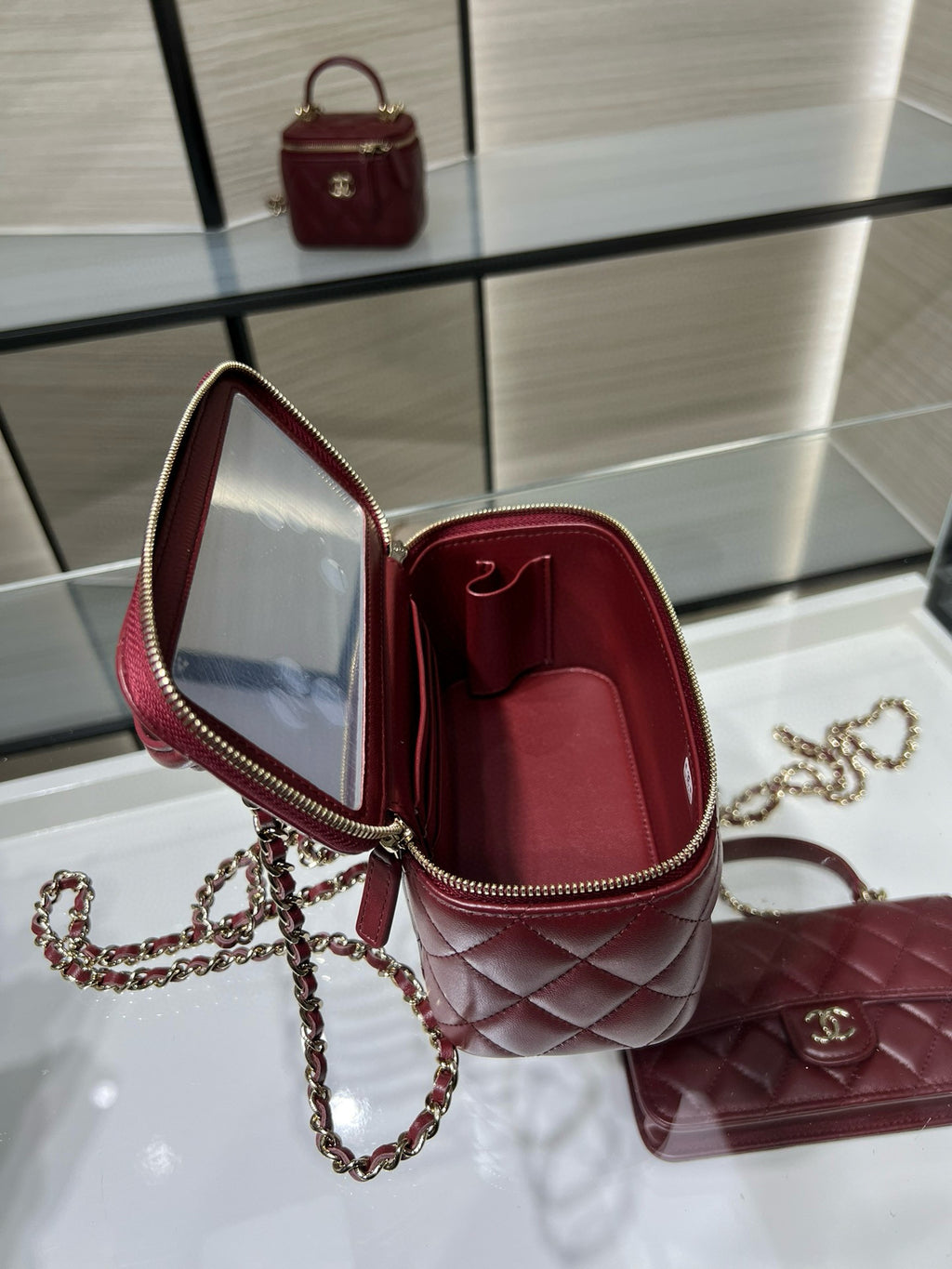 Quilted dark red mini bag open to show red fabric lining and zip edge.