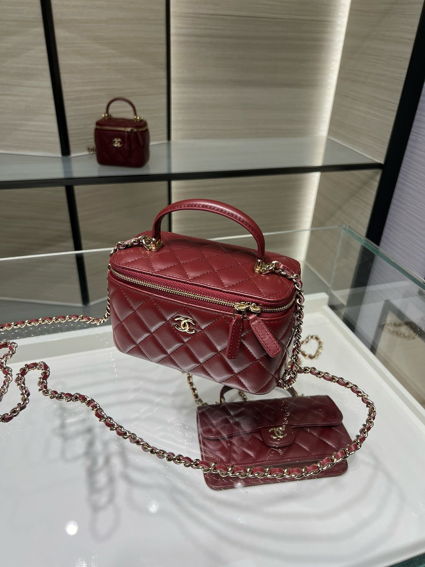 Dark red quilted top-handle bag with chain strap and flap clasp.