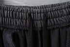 Textured elastic waistband on dark gray pants