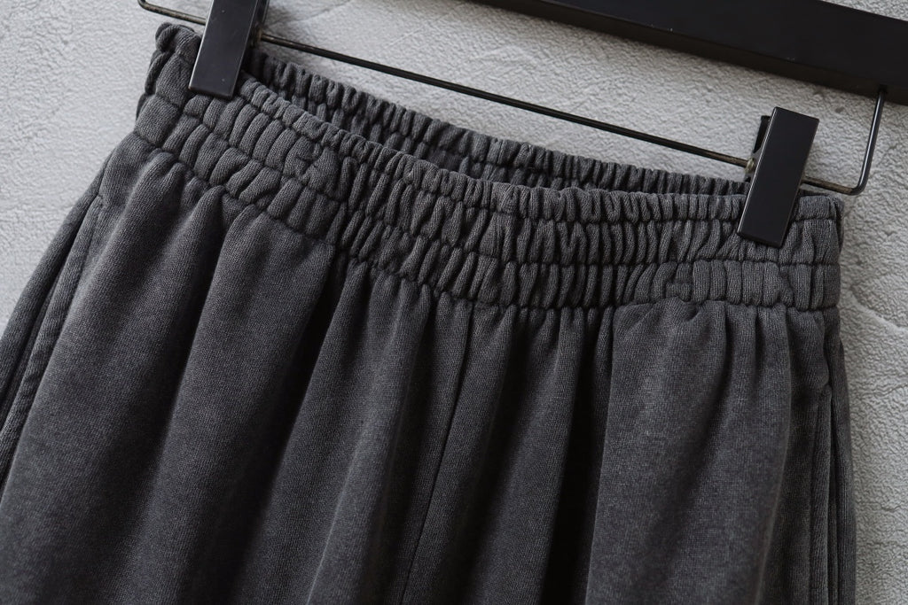 Elastic waistband with gathered pleats on dark gray pants