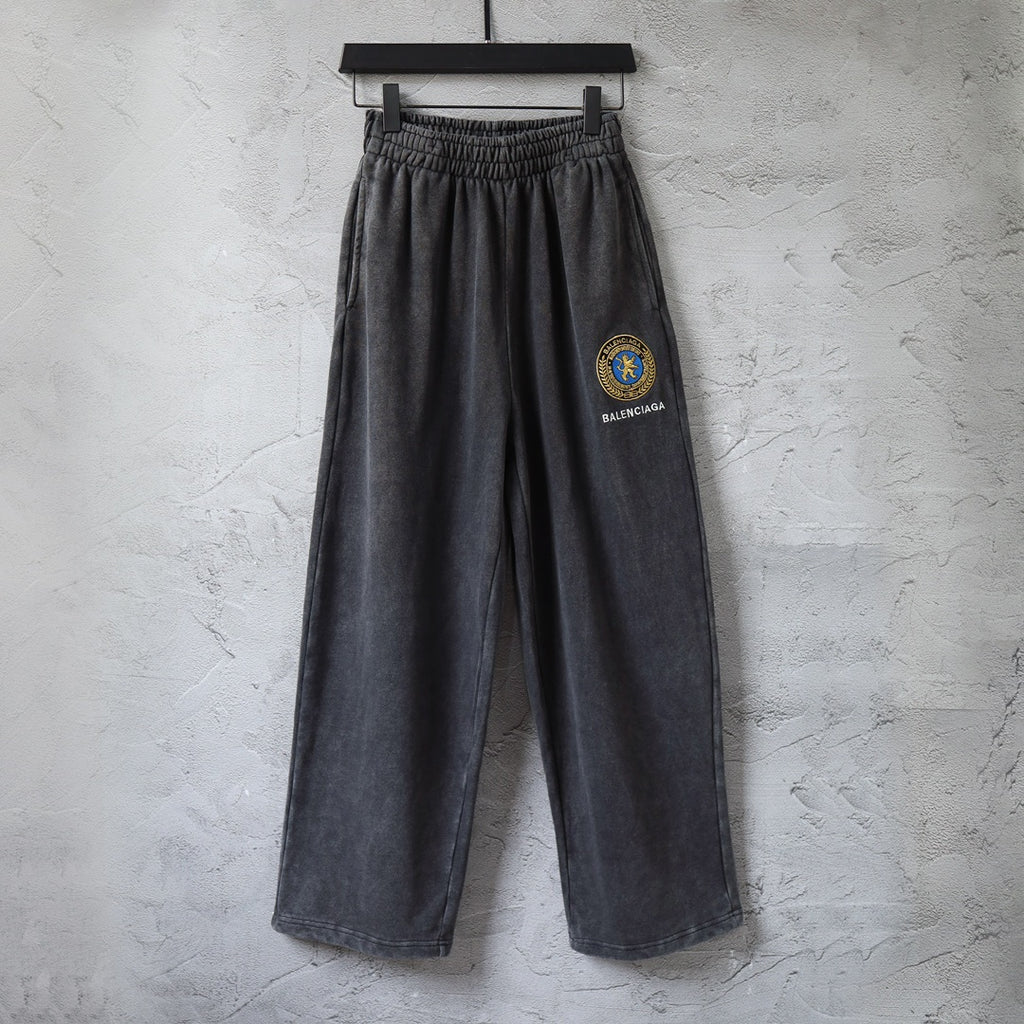 Balenciaga charcoal wide-leg pants with elastic waist and crest patch on leg.