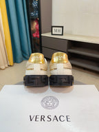 Back view of white and gold sneakers with textured black heel sole