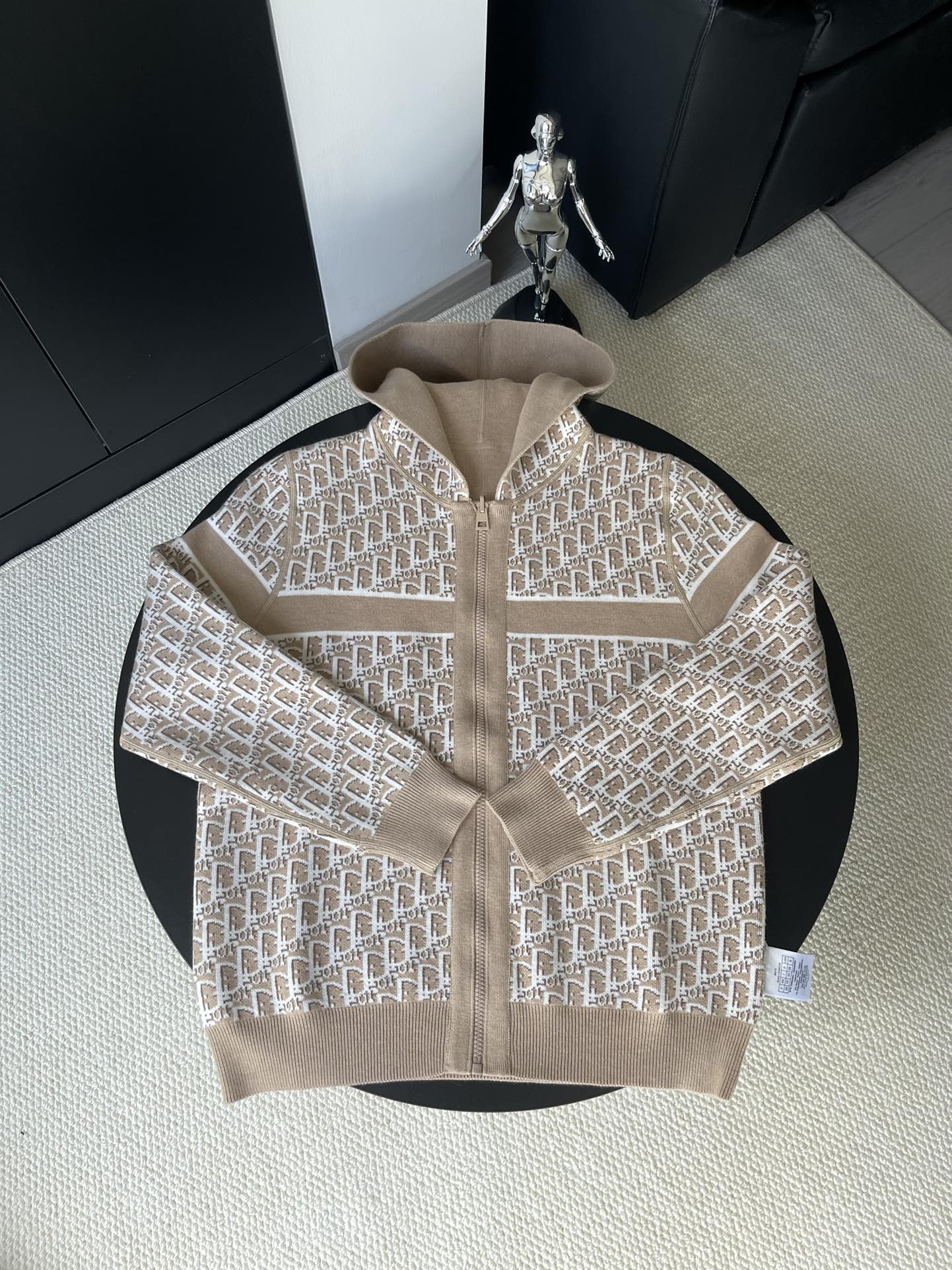 Beige hooded jacket with all-over geometric logo pattern and front zip