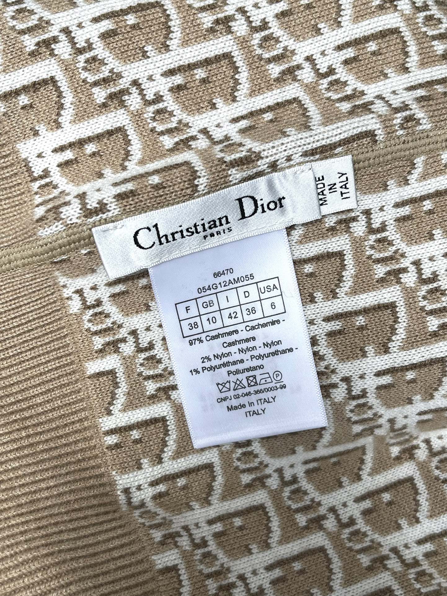 Clothing label inside beige hooded jacket with size and fabric details