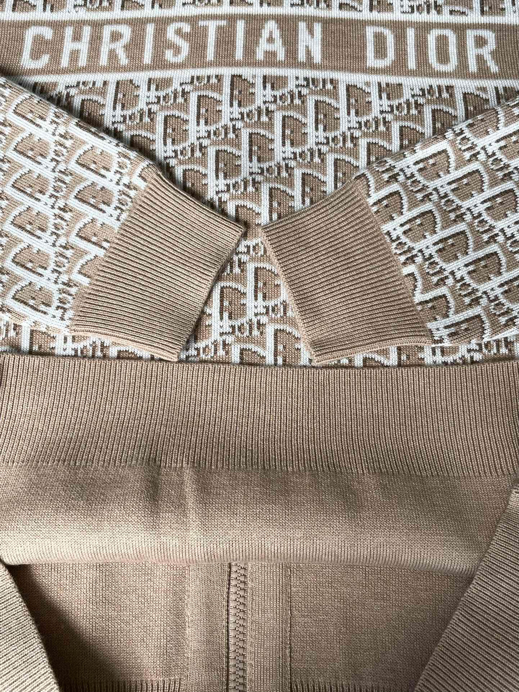 Close-up of beige hooded jacket with all-over Christian Dior logo pattern