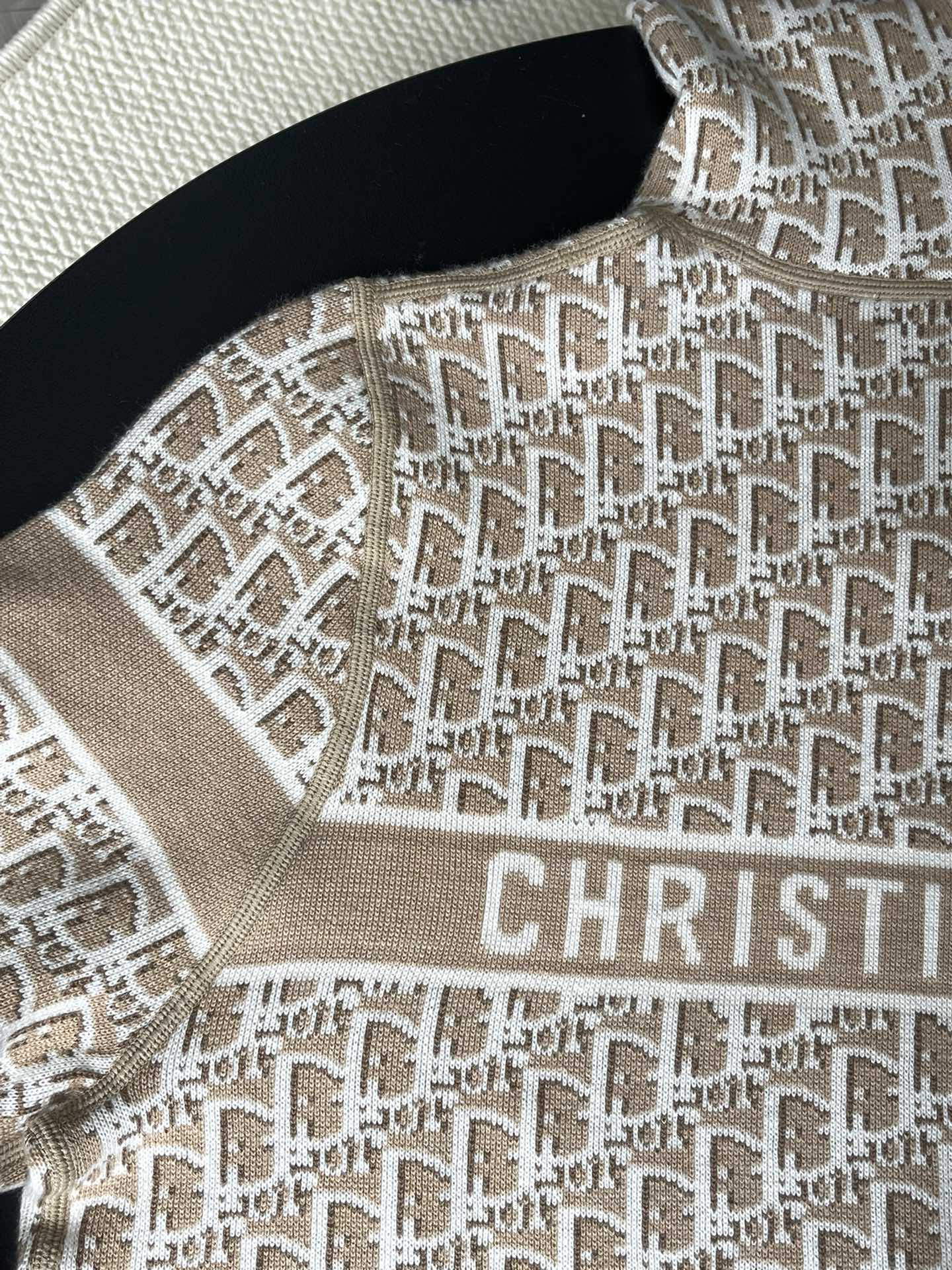 Close-up of beige hooded jacket fabric with repeating geometric Dior logo