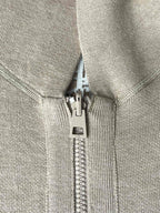 Beige zip pull and zipper on hooded jacket with fabric-lined hood