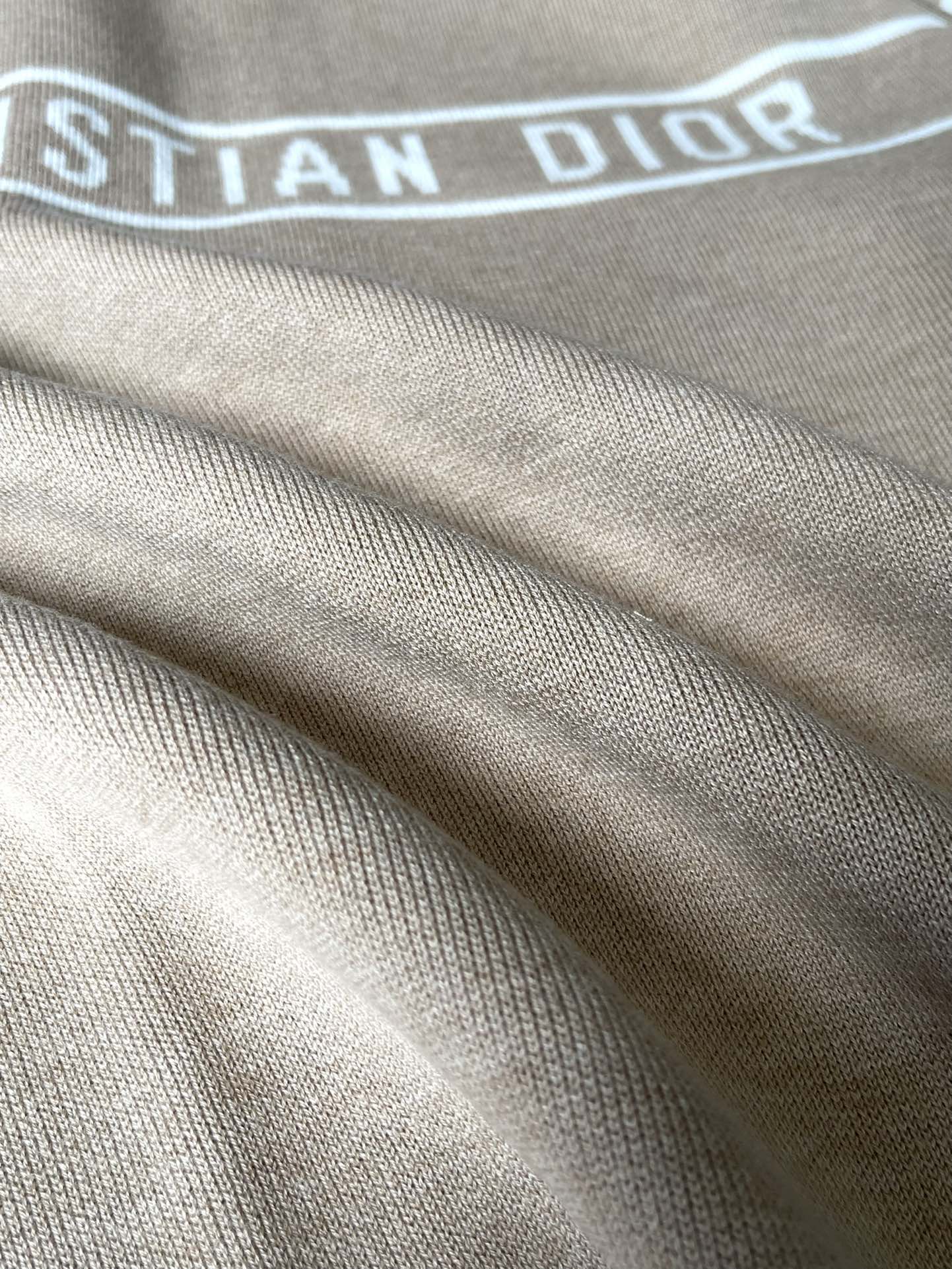 Beige ribbed cuffs and hem detail on a zip-up hooded jacket