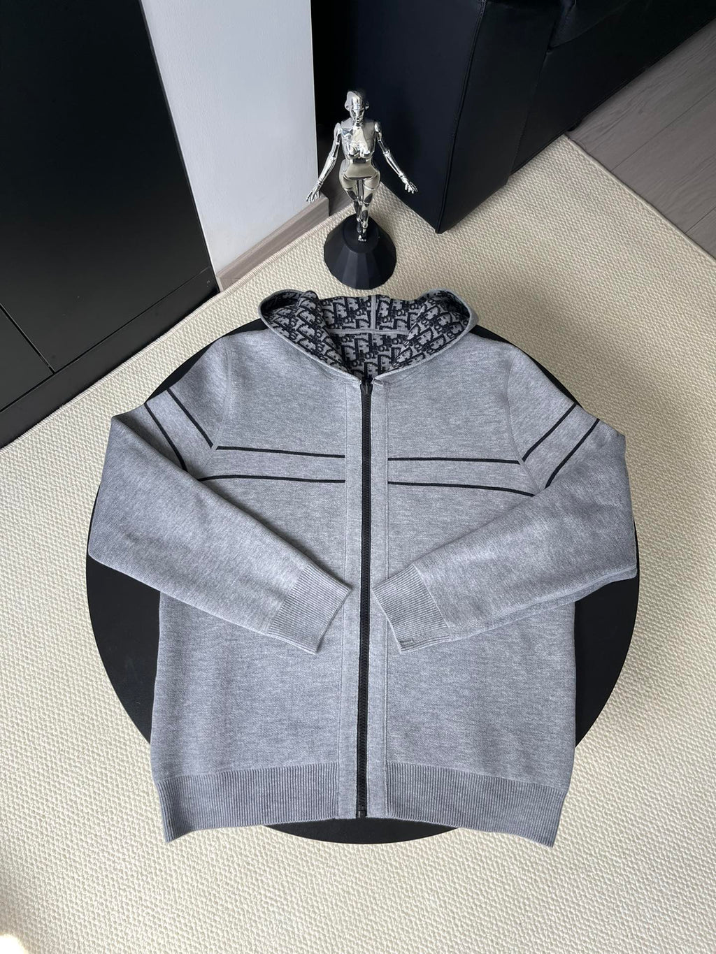 Gray hooded zip-up sweater with black zipper and stitched chest pockets
