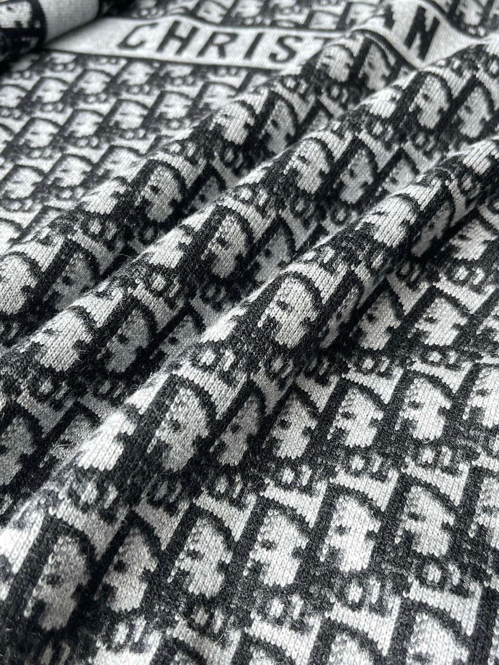 Black and white patterned knit fabric with Dior-style motif texture