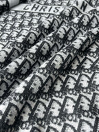 Black and white patterned knit fabric with Dior-style motif texture