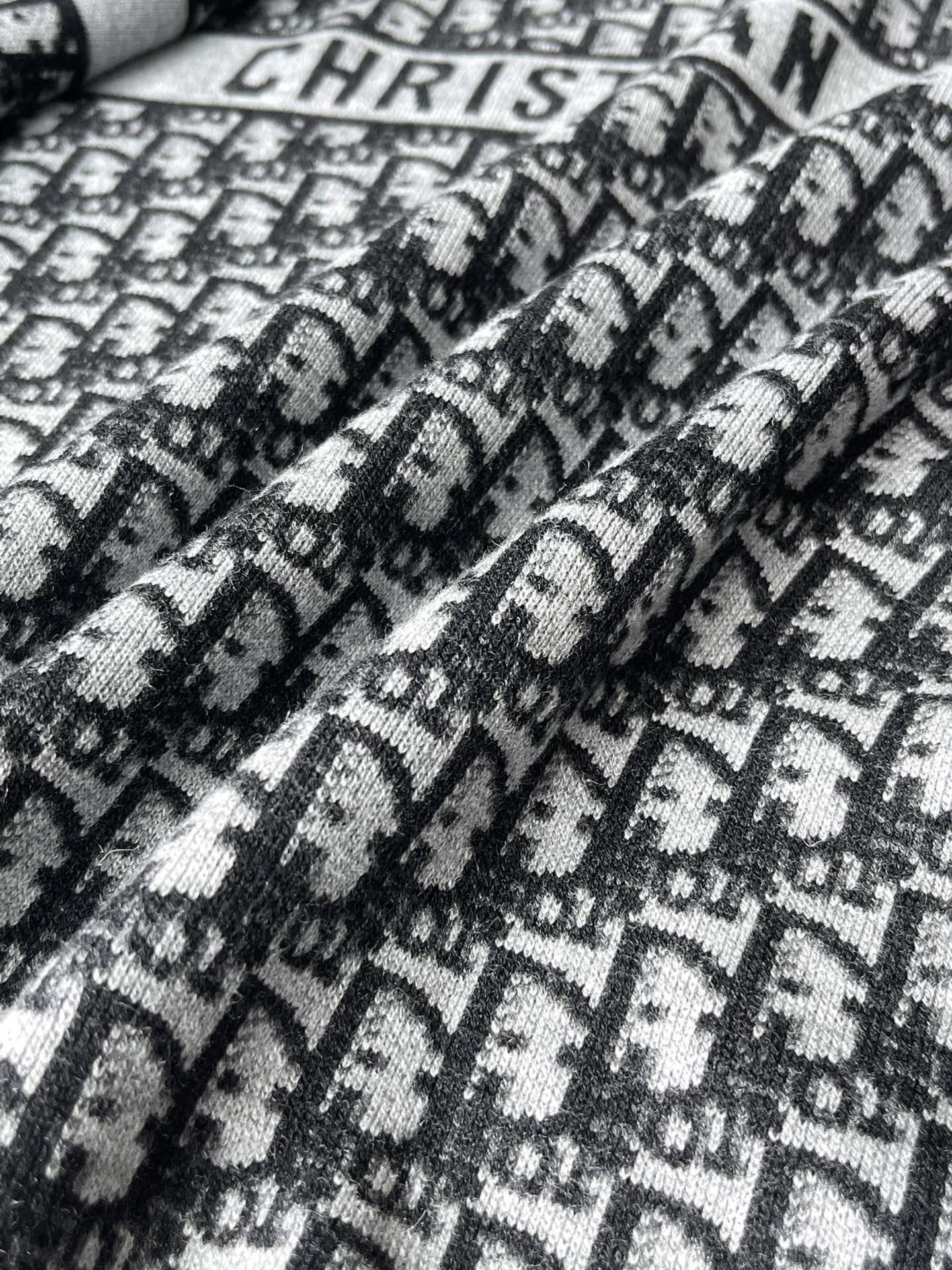 Black and white patterned knit fabric with Dior-style motif texture