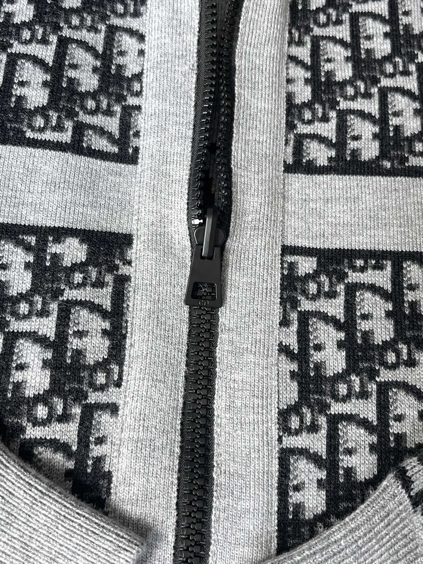 Close-up of black zipper on patterned knit hooded sweater front