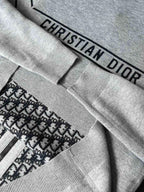 Gray fabric cuff with “CHRISTIAN DIOR” label and ribbed knit trim