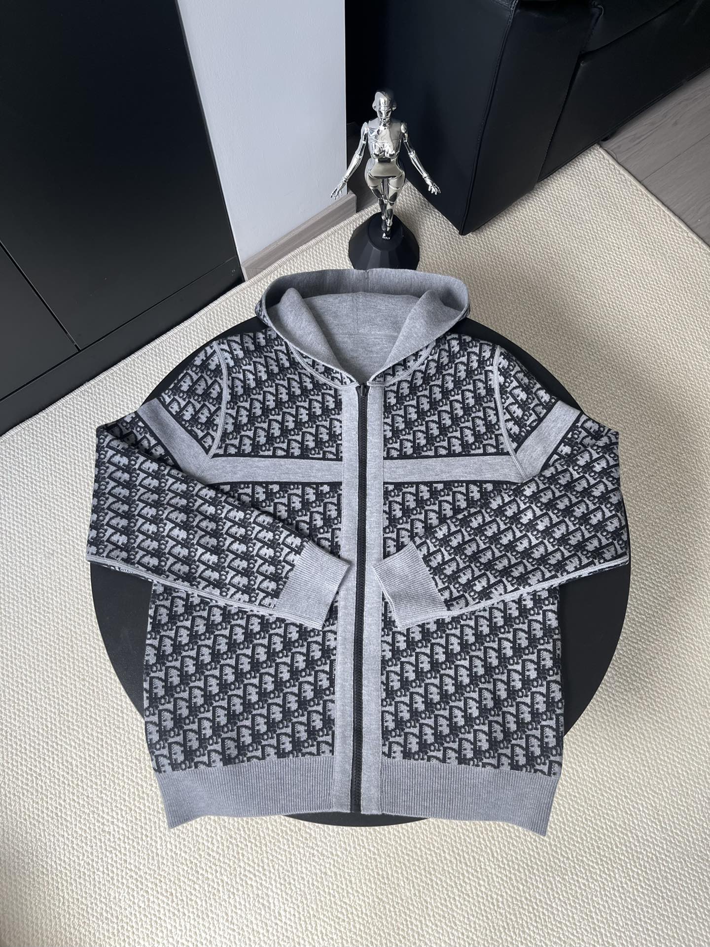 Black and gray patterned hooded zip-up sweater with white embroidered logo details