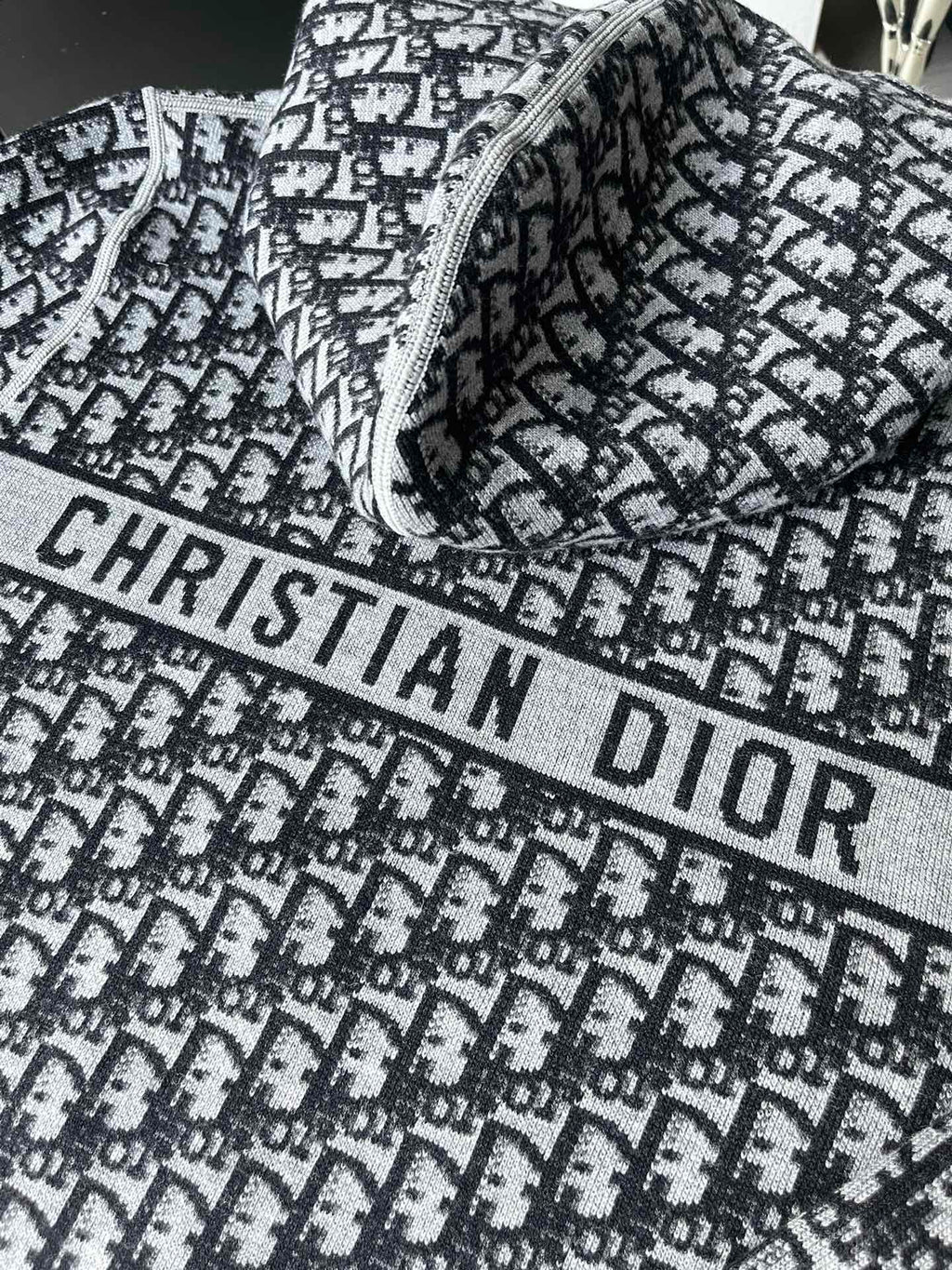 Black and white patterned hooded zip-up sweater with large “CHRISTIAN DIOR” print