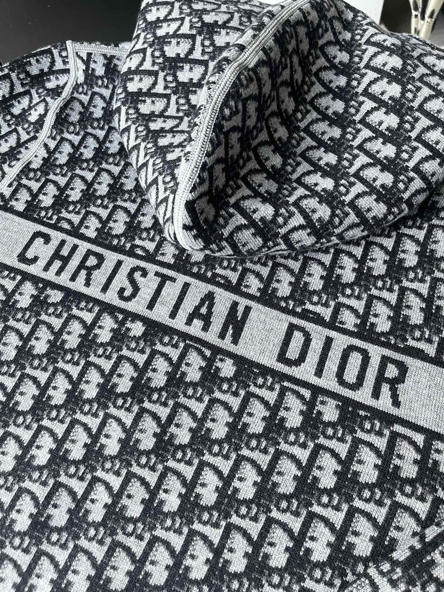 Black and white patterned hooded zip-up sweater with large “CHRISTIAN DIOR” print