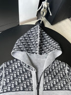 Black and white patterned hooded zip-up sweater with open hood and central zipper