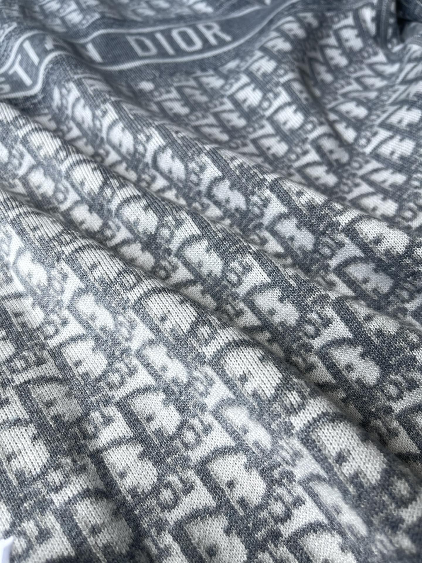 Dior long hooded zip jacket close-up: allover “DIOR” monogram knit pattern