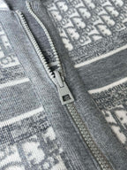 Gray hoodie zipper detail with metal pull on patterned fabric