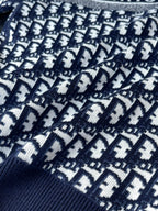 Close-up of navy Dior jacquard knit with white motif repeat